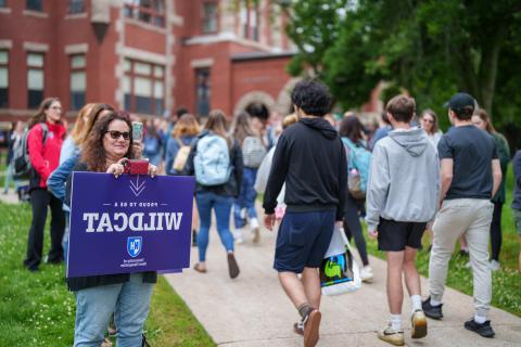 Large group of students walk through UNH campus